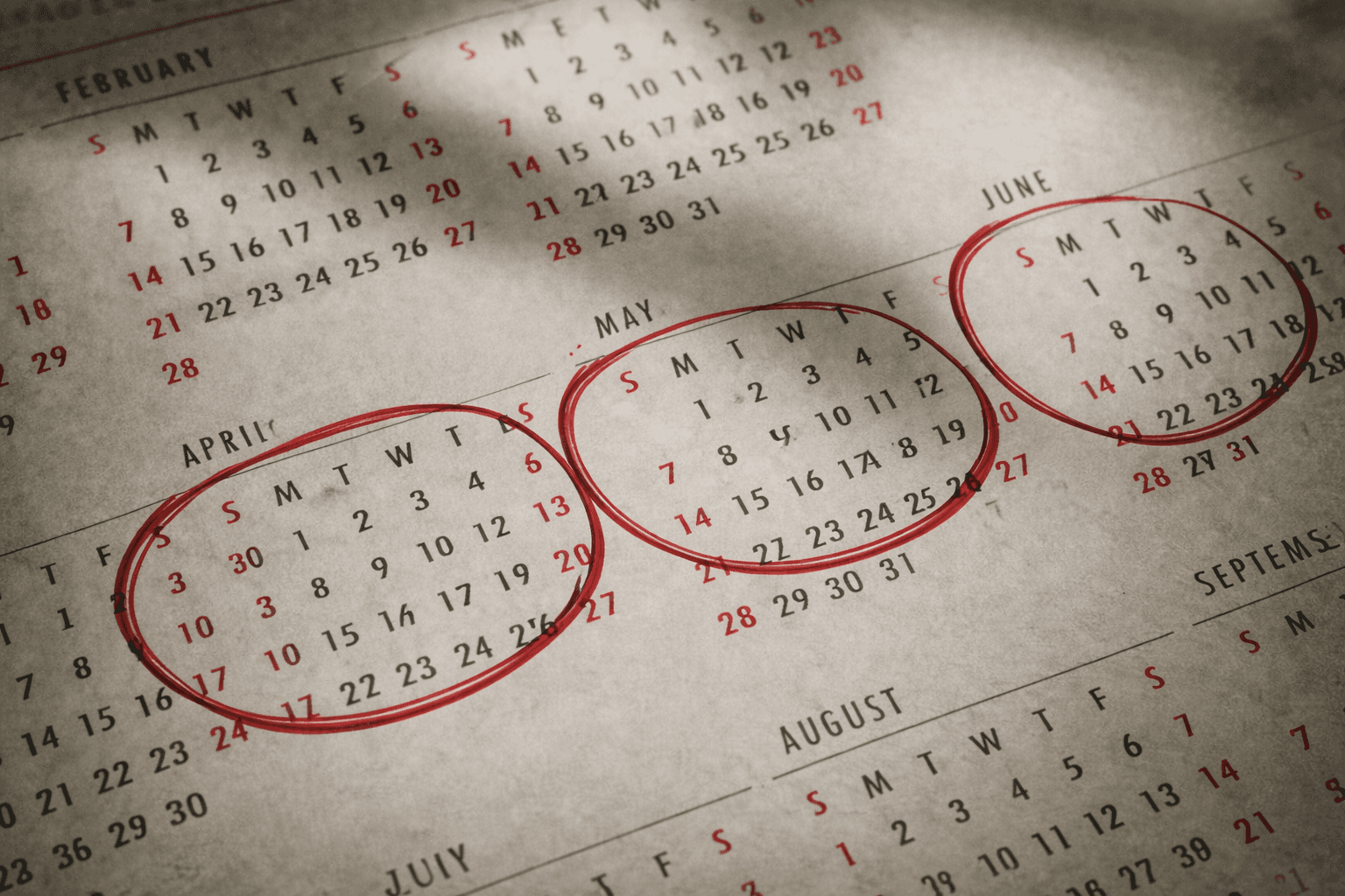 Calendário com os meses de abril, maio e junho circulados à caneta, destacando o período usado no cálculo do seguro social no Japão e seu impacto financeiro ao longo do ano.